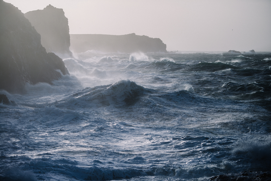spumey waves crashing on rocky coast